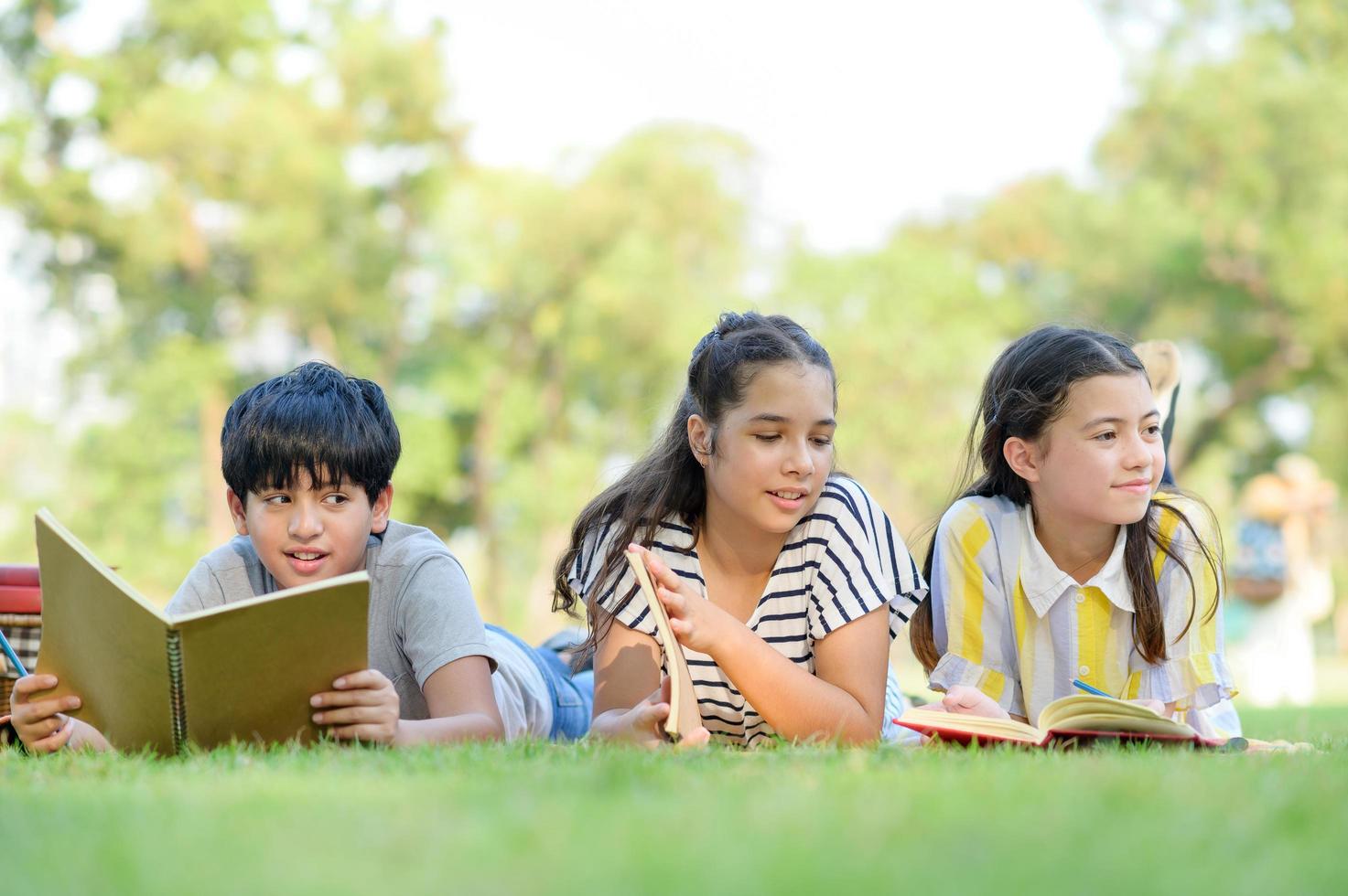 A half-Thai Indian boy and a half-Thai-European girl friend learning outside of school in the park photo