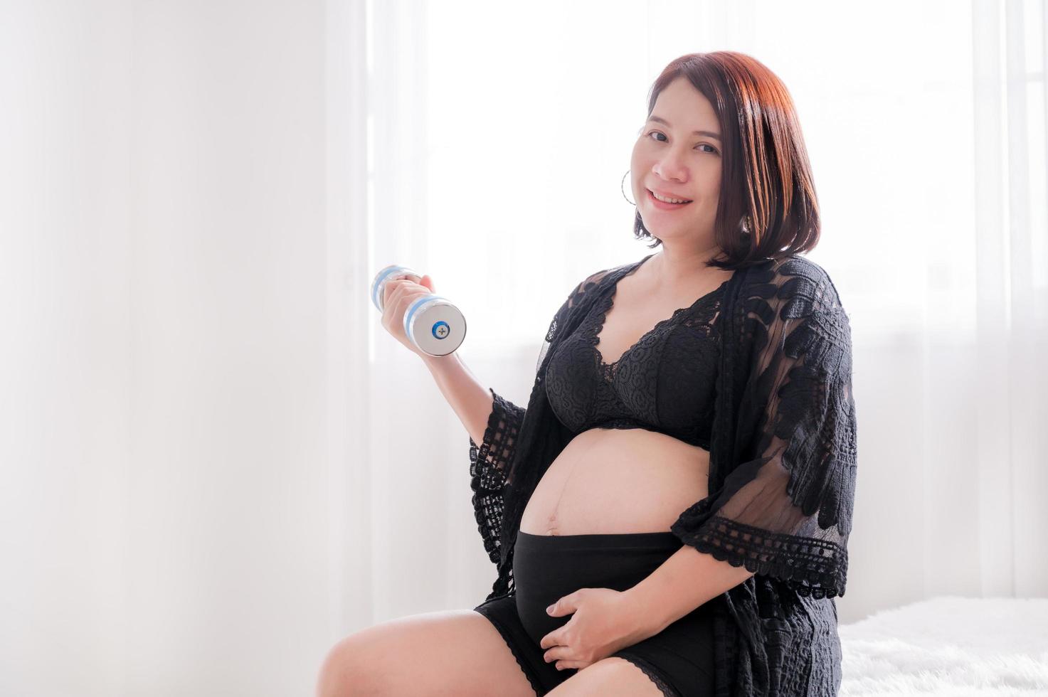 Beautiful pregnant women sitting in the bedroom and relax with exercise for good health photo