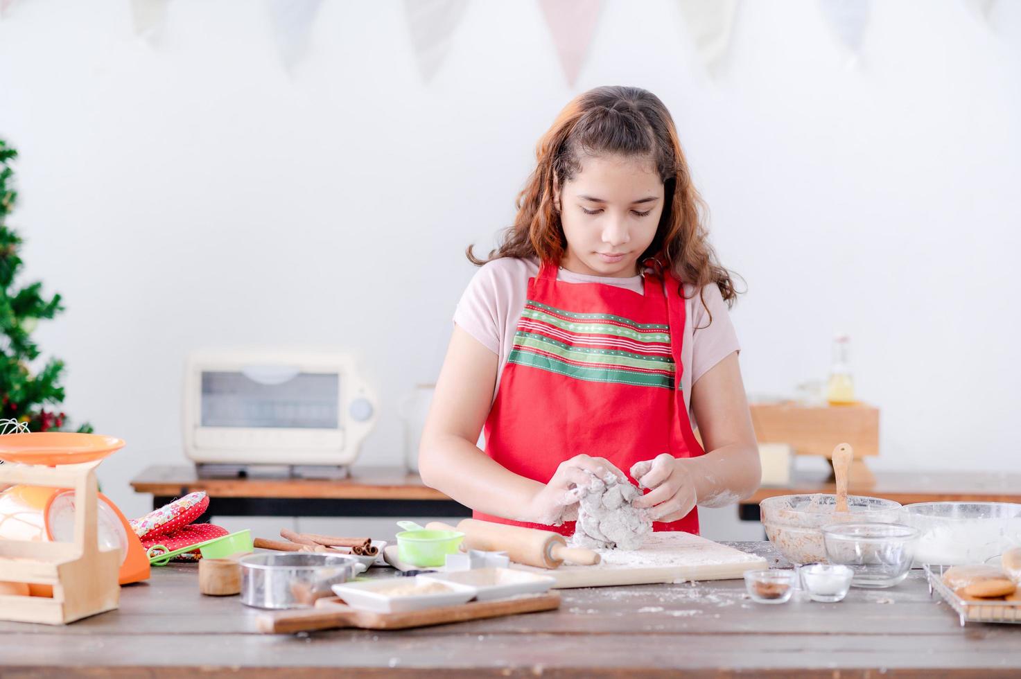 European girls prepare tools and ingredients for making gingerbread during Christmas and New Year celebrations photo