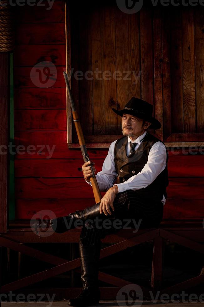 A senior sheriff holds a rifle while guarding security in an outlaw western area photo