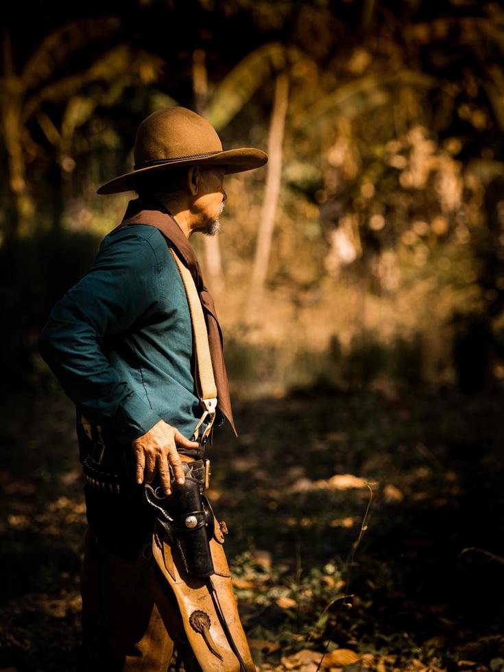 The senior cowboy stands preparing for a gunfight against opponents in the outlawed western lands photo