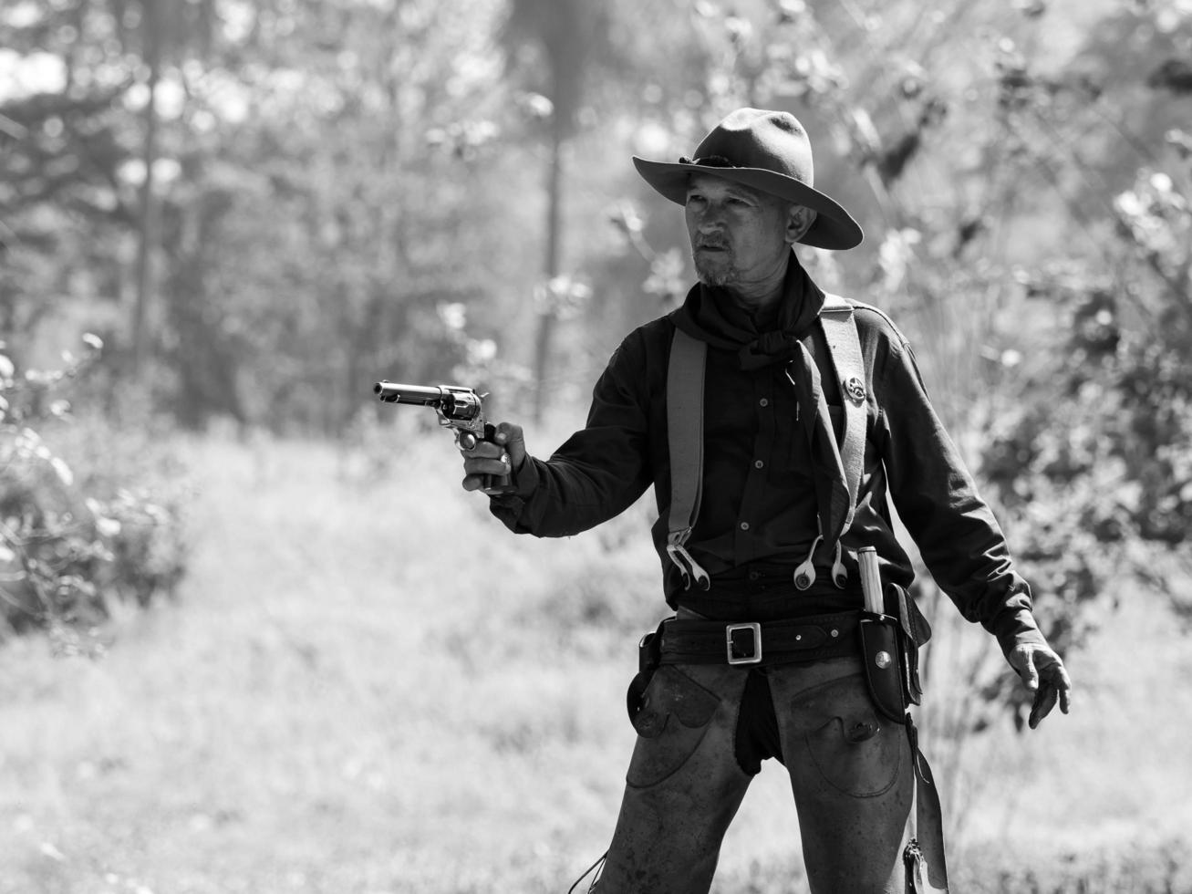 The senior cowboy stands preparing for a gunfight against opponents in the outlawed western lands photo