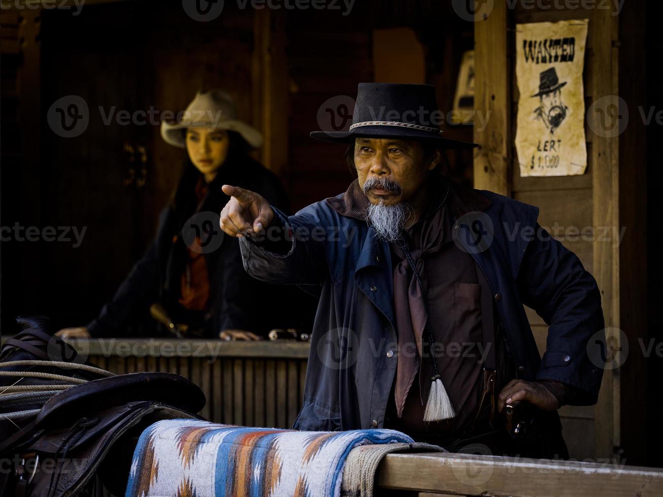 el viejo vaquero occidental y la joven vaquera se preparan para defenderse en una tierra donde la gente tiene que defenderse porque la ley aún está por llegar foto