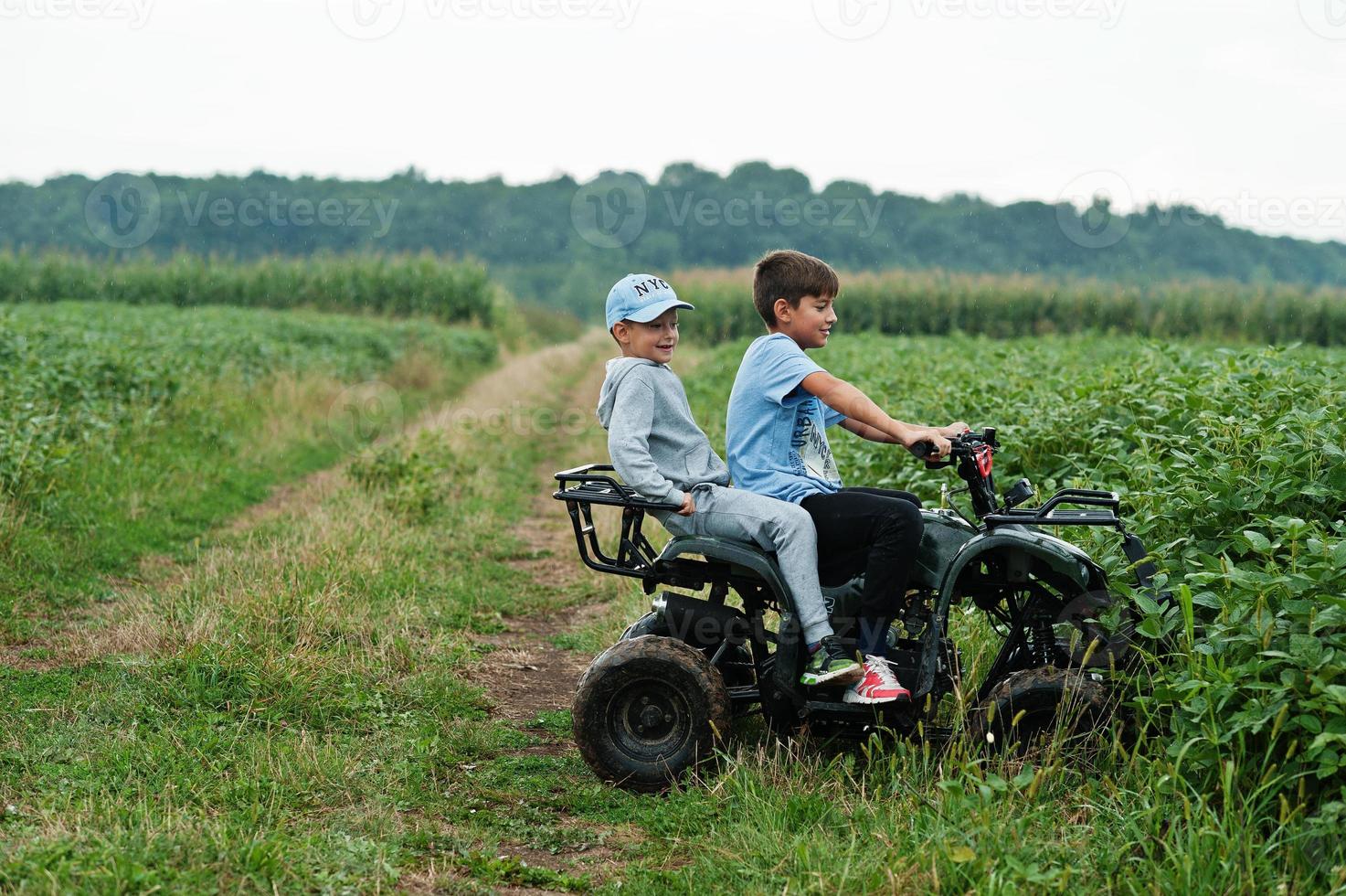 dos hermanos conduciendo quads de cuatro ruedas. momentos de niños felices. foto