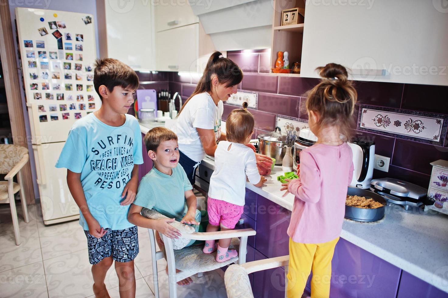 madre con hijos cocinando en la cocina, momentos felices de los niños. foto