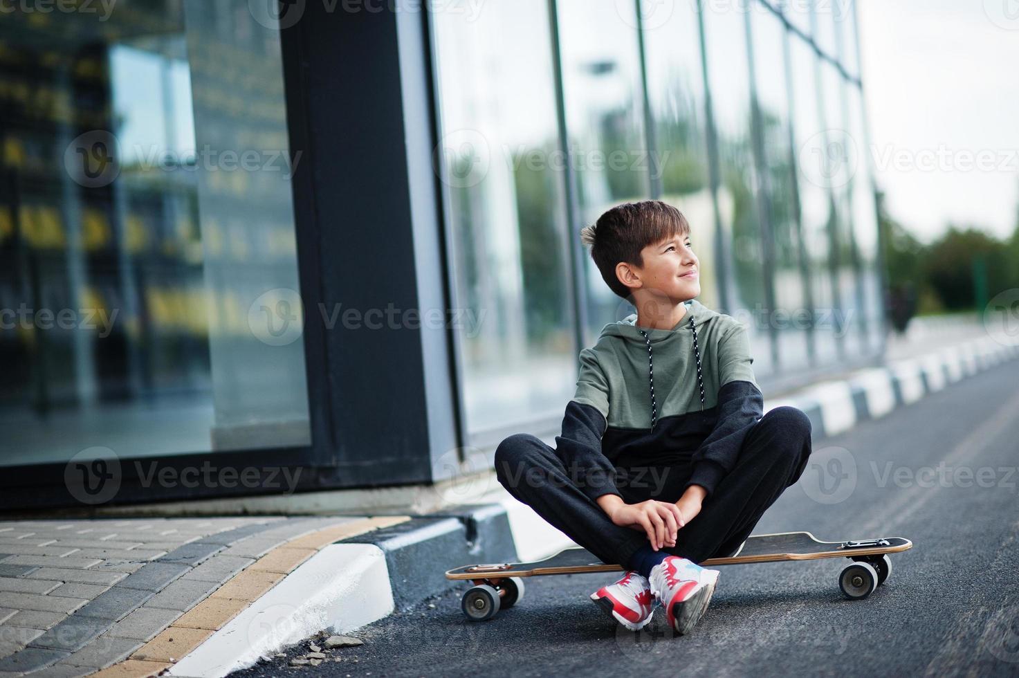 Teenager boy in a sports suit with longboard. photo