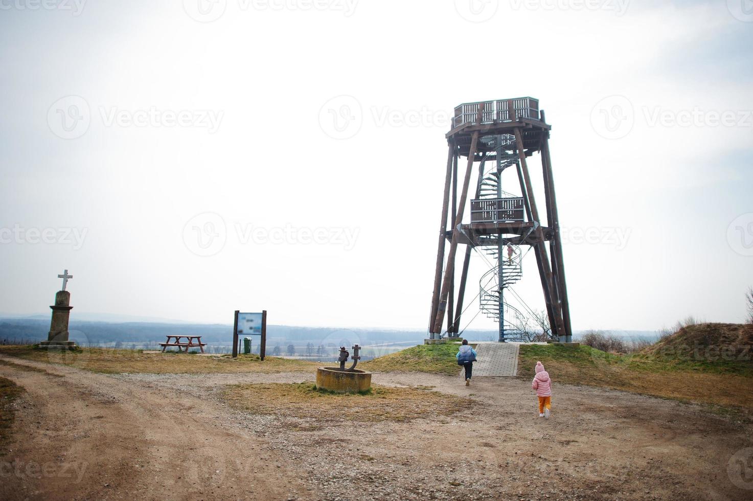 Kids running to wooden observation tower. photo