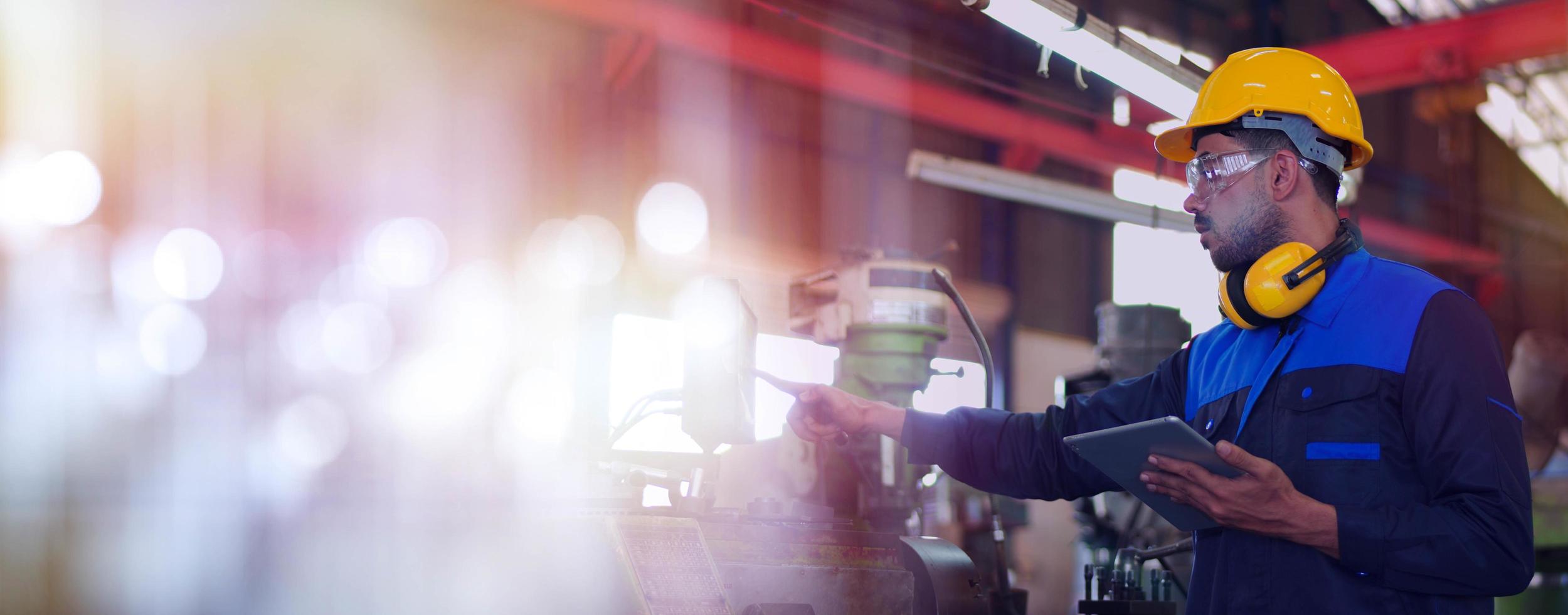 Professional maintenance engineer, technician worker, repairman wear uniform, safety hard hat using tablet computer checking control machine in factory. Manufacturing heavy machine Industry concept. photo