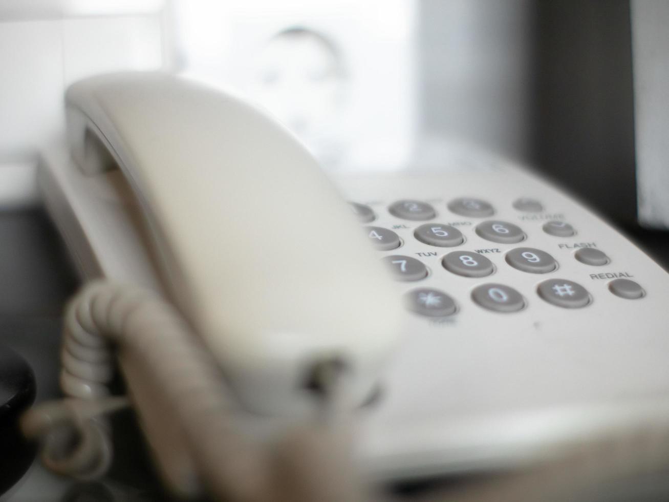 white wired phone on the table when not in use photo