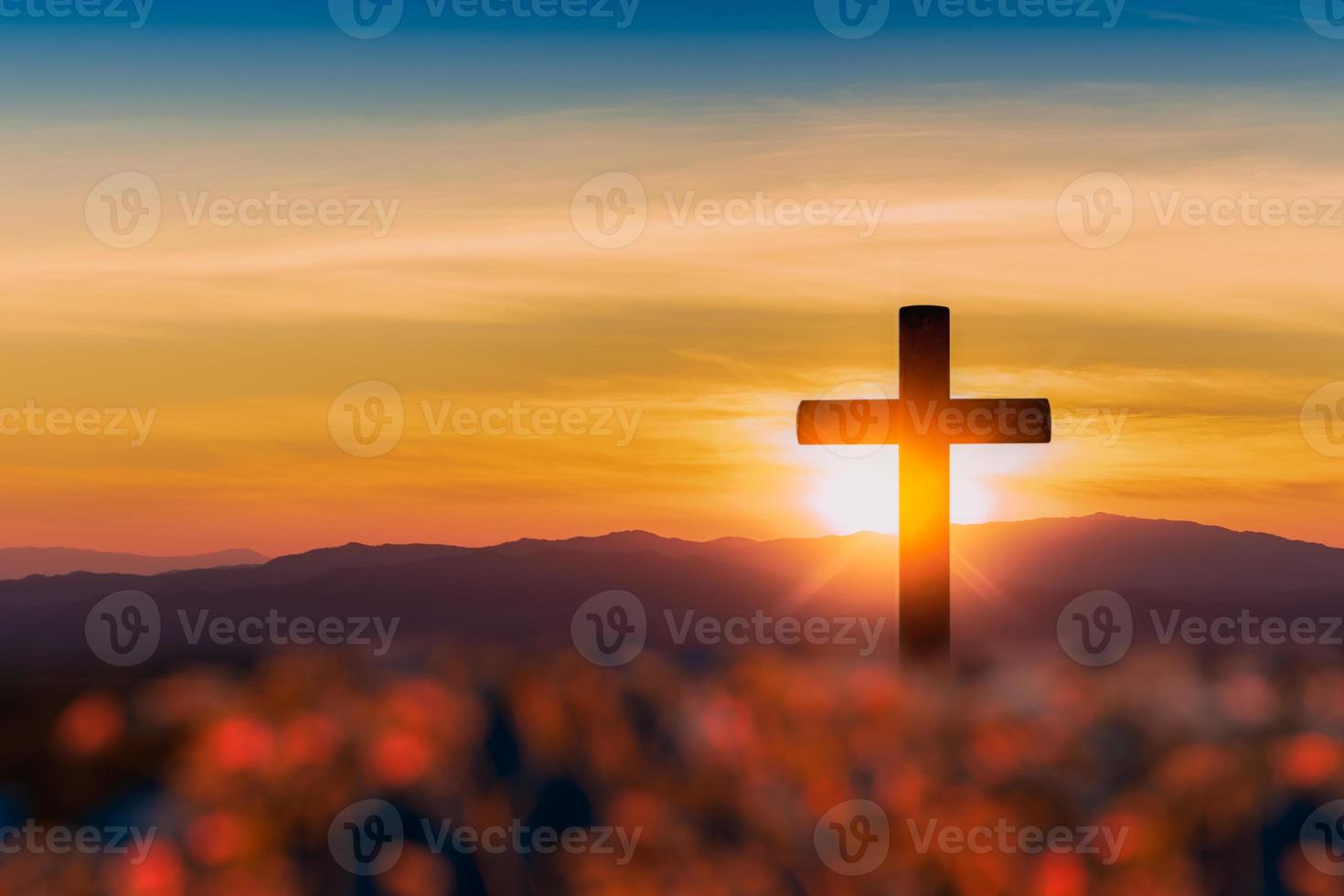 silueta de cruz sobre fondo de puesta de sol de montaña. foto