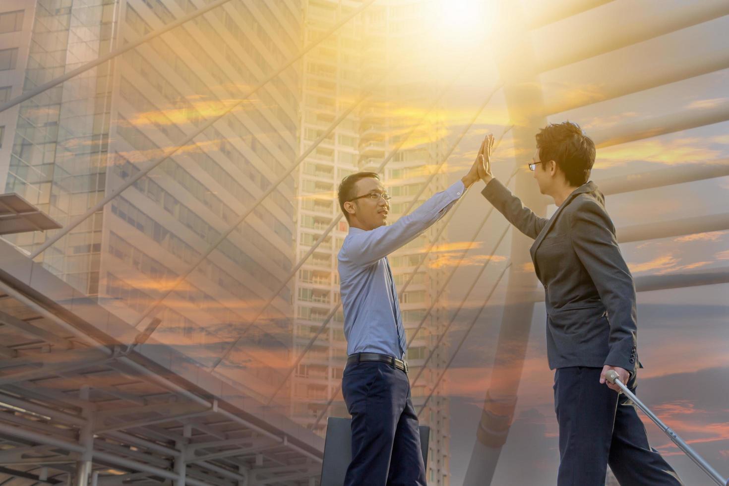 Success and Happiness Team concept, Business man Celebration putting their hands together in unity outside office sunset city double exposure background. photo