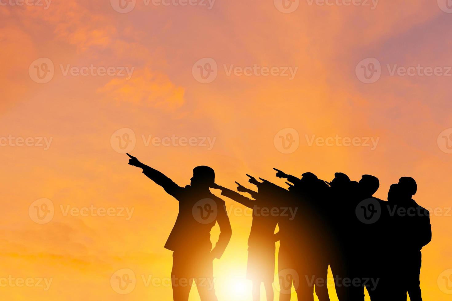 Silhouette of Business people success team with clipping path standing with pointing to the target sunset evening sky background, Success and Happiness Teamwork concepts photo