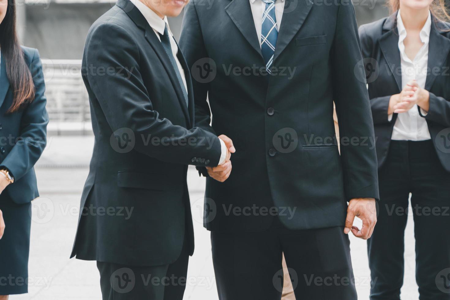 Success and Happiness concept, Business man handshake at outside office over blurred team background photo