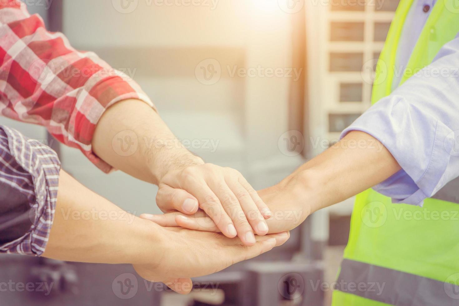 concepto de trabajo en equipo de éxito, equipo de personas de ingenieros de negocios uniéndose a los antecedentes del sitio de construcción foto