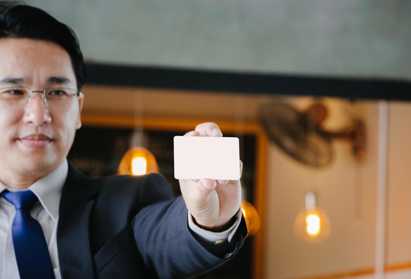 hombre de negocios mostrando su tarjeta de crédito en blanco, concepto de maqueta foto