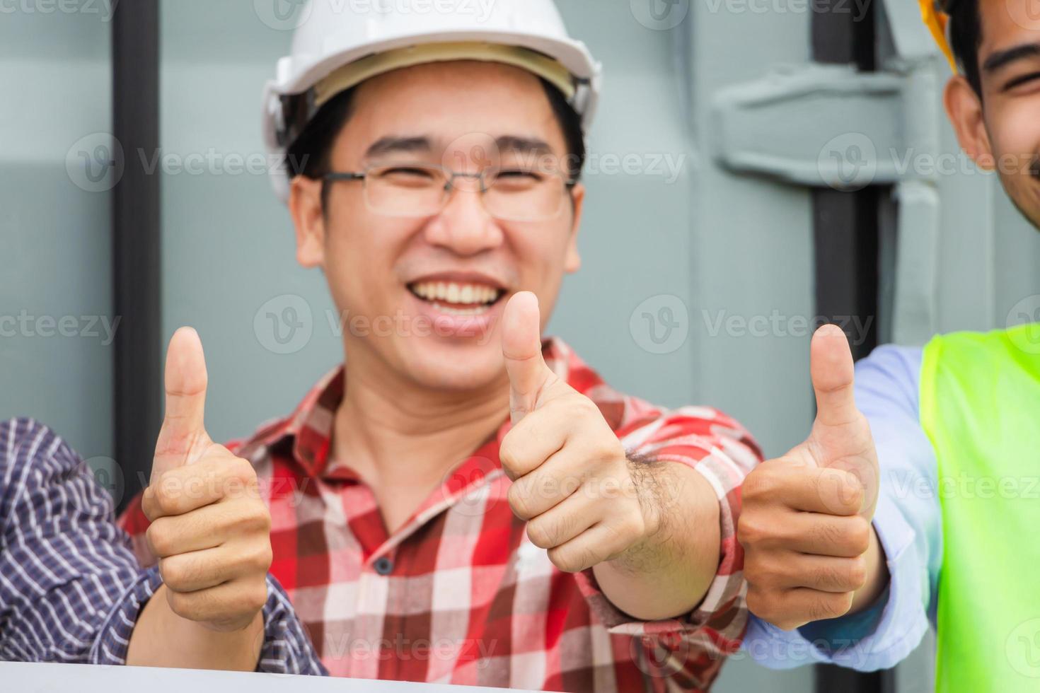 Cheerful engineer and factory worker man team smiling with giving thumbs up as sign of success photo