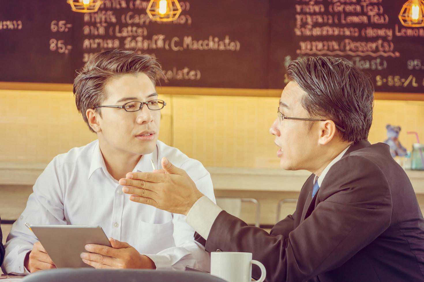 Close up of Business man team meeting working connected with technological devices in a modern coffee shop. photo