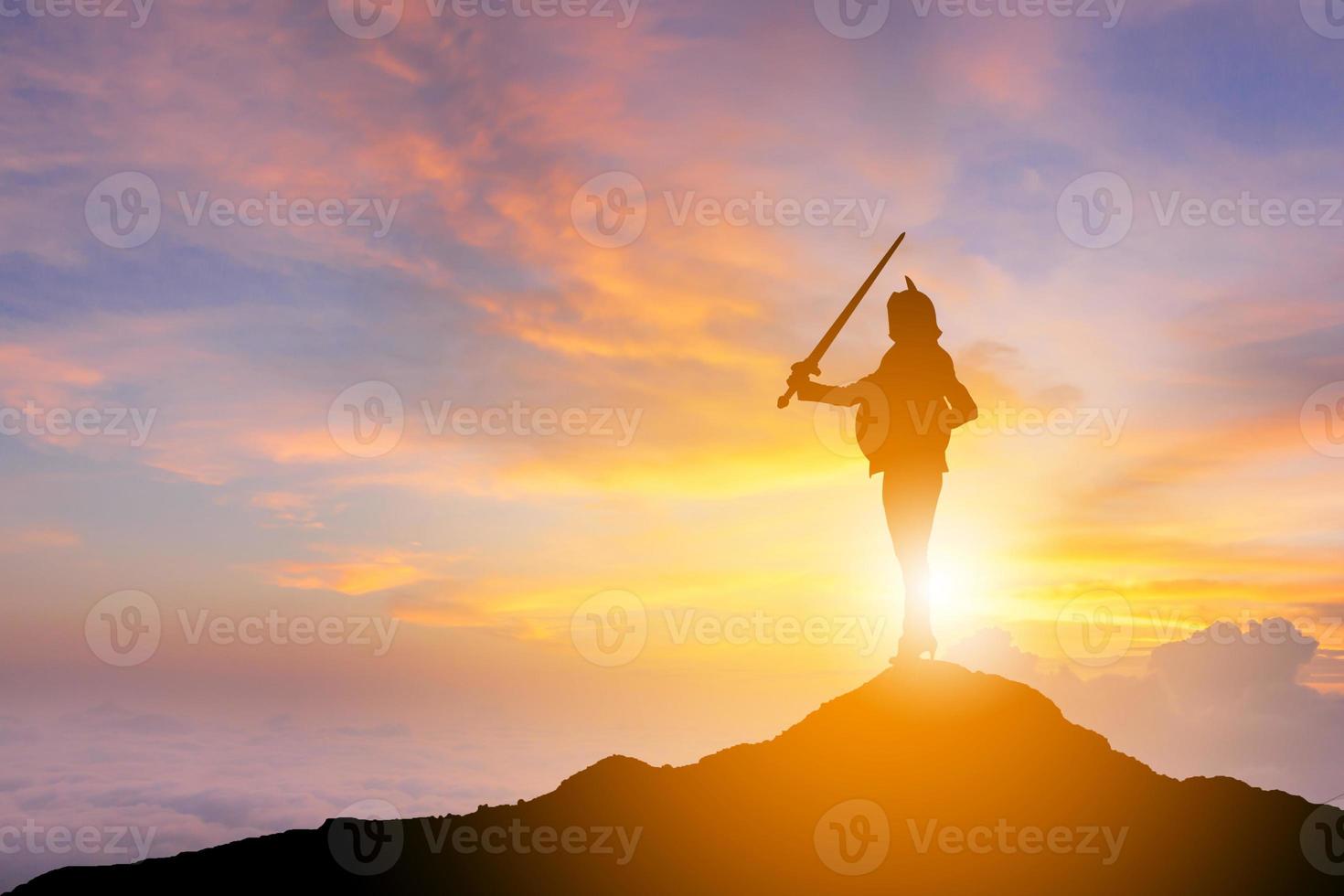 silueta de mujer de negocios espada y escudo de caballero en el fondo de la puesta de sol, luchando contra el concepto de guerrero de negocios, con camino de recorte. foto