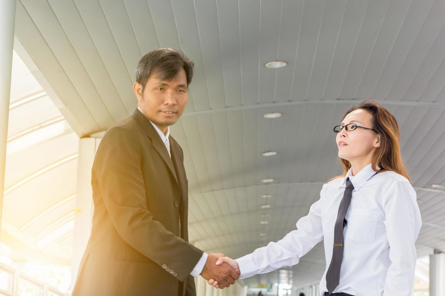 Success and Happiness concept, Business man and businesswoman handshake at city outside office. photo