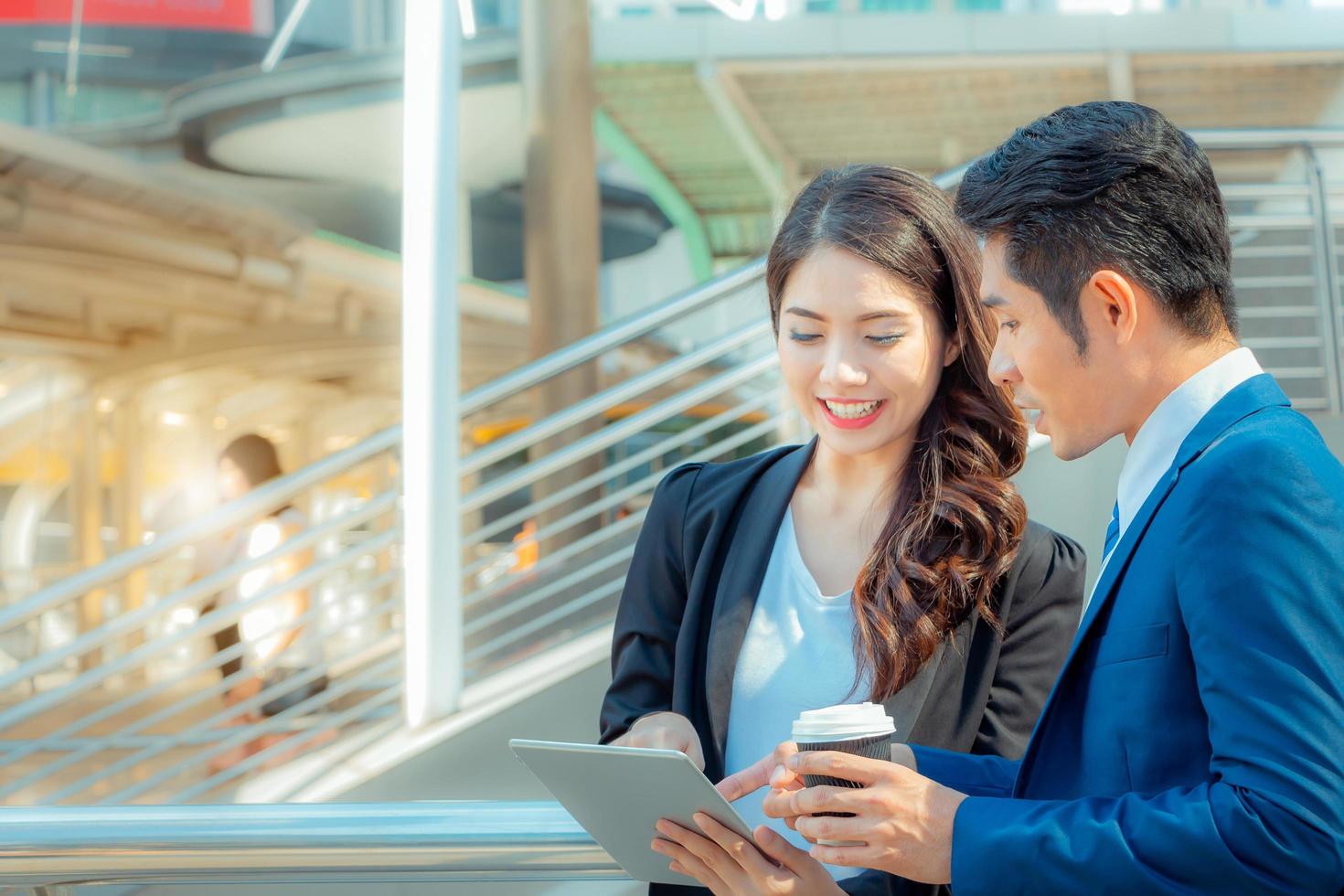 Close up of young businesswomen and smart business man with smartphone and coffee cup in hand photo