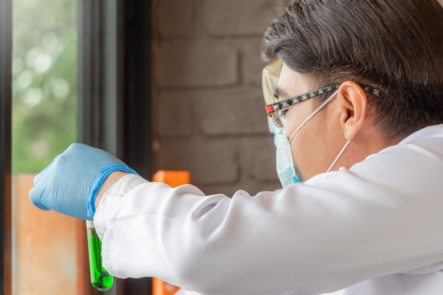 Doctor analyzing medical test tubes examining beaker with fluid, Scientist researching and learning in a laboratory photo