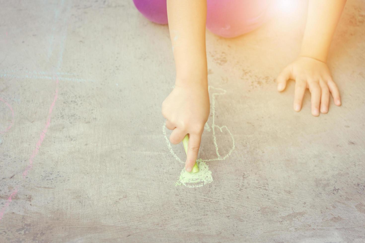 Close up of Kid hand drawing a cartoon on the floor photo