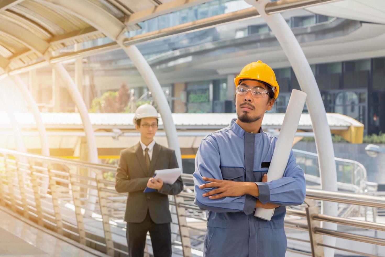 la construcción y el mantenimiento piensan en un gran concepto, la planificación de ingenieros de negocios y el arquitecto masculino en casco con antecedentes de ciudad. foto