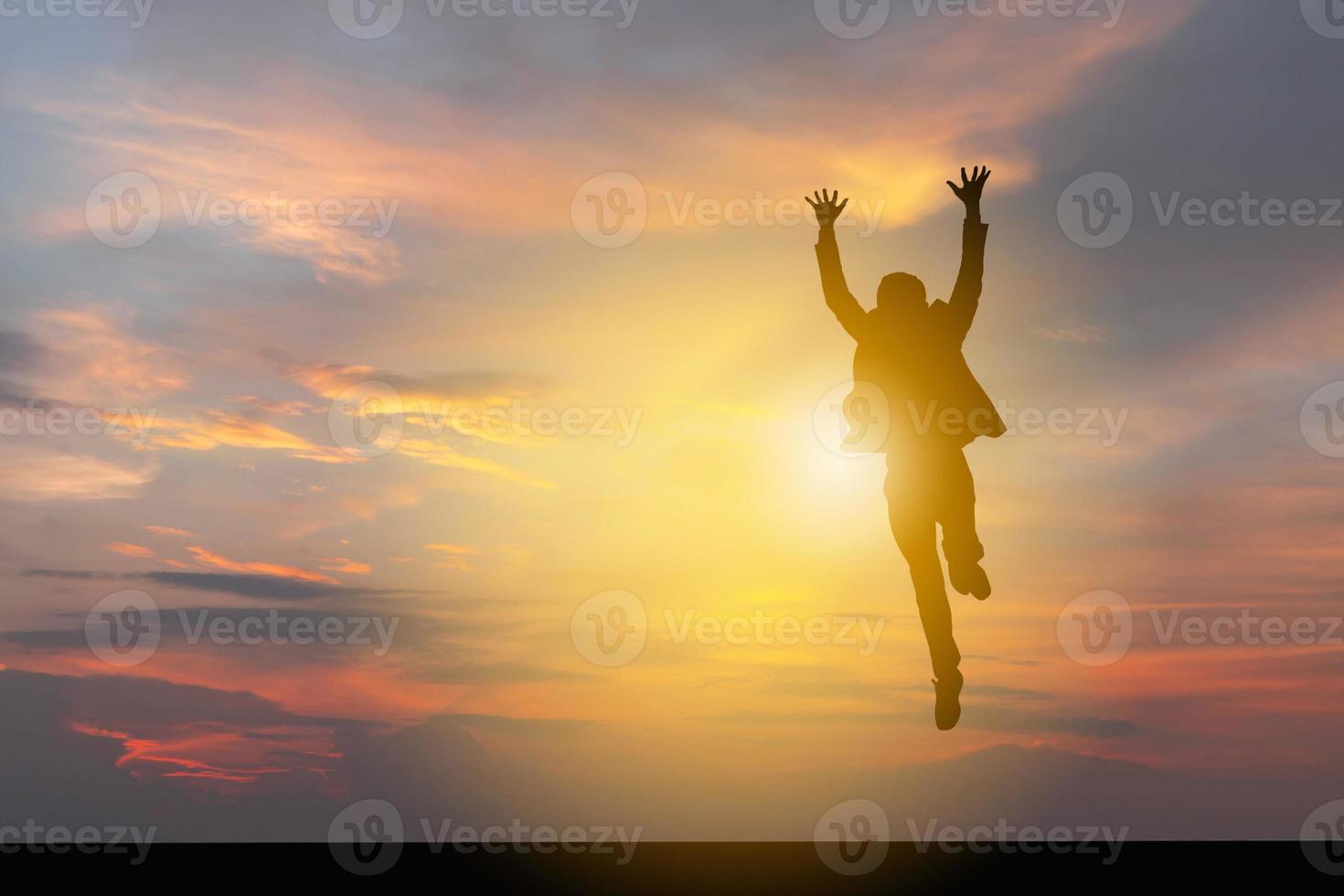 silueta de hombre de negocios celebración éxito felicidad puesta de sol noche cielo fondo foto