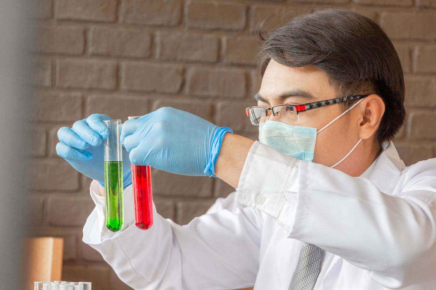 médico que analiza tubos de ensayo médicos que examinan el vaso de precipitados con líquido, científico que investiga y aprende en un laboratorio foto