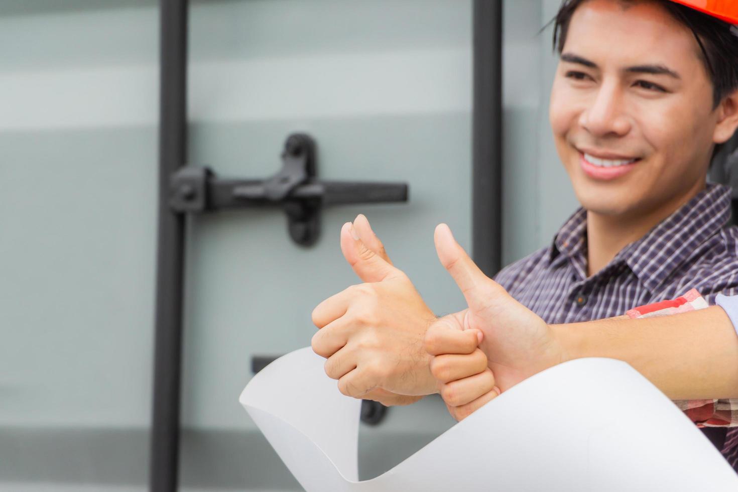 Cheerful engineer and factory worker man team smiling with giving thumbs up as sign of success photo