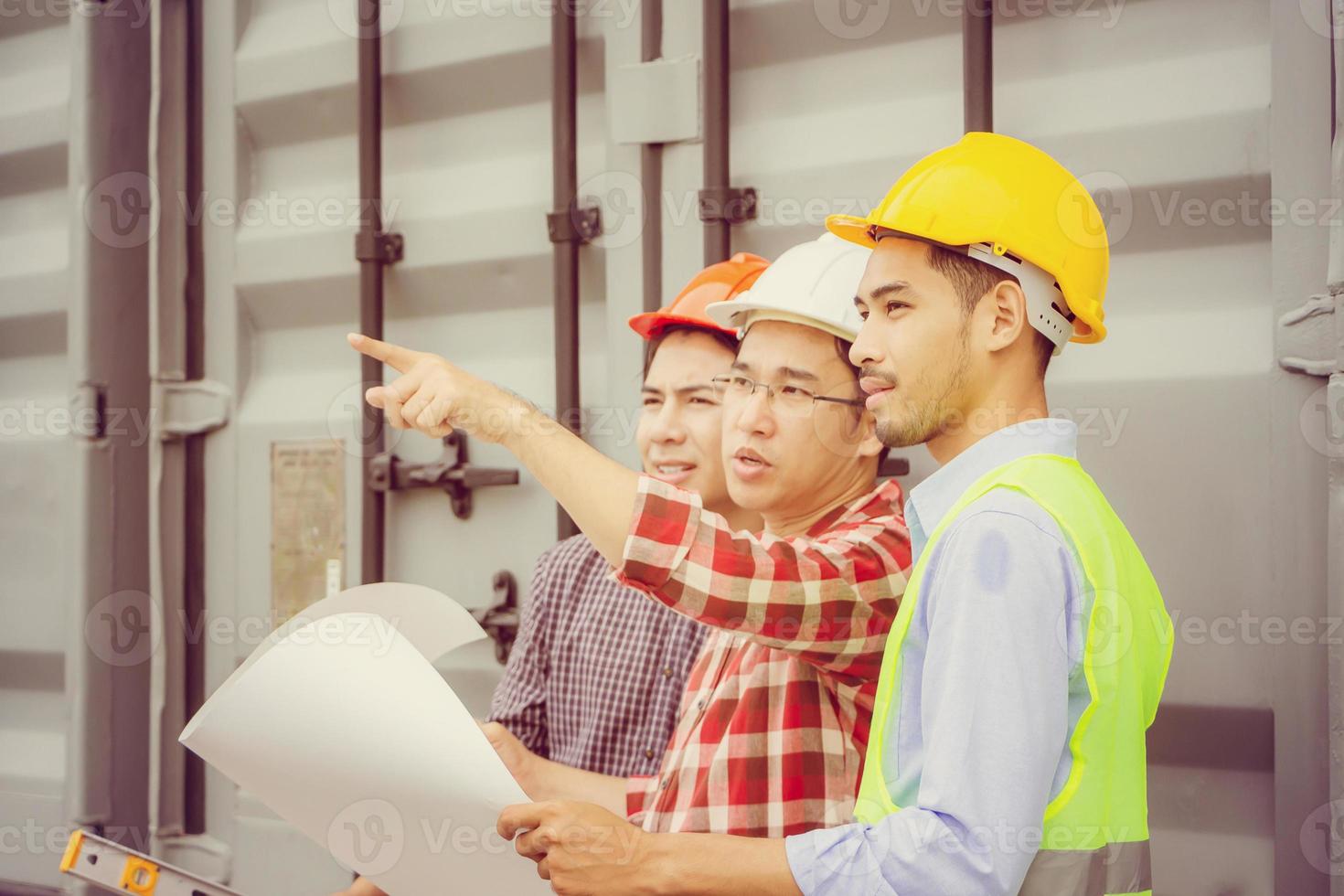 ingeniero y trabajador revisando y planificando el proyecto en el sitio de construcción, hombre mirando al cielo sobre un fondo borroso foto