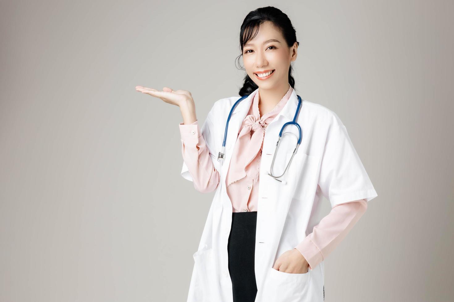 Portrait of an attractive young female doctor in white coat. photo