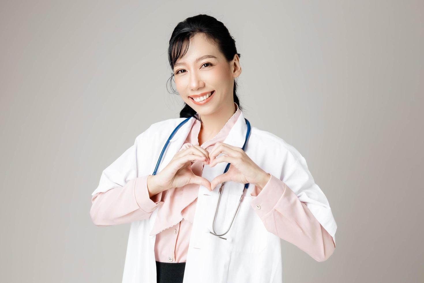 Portrait of an attractive young female doctor in white coat. photo