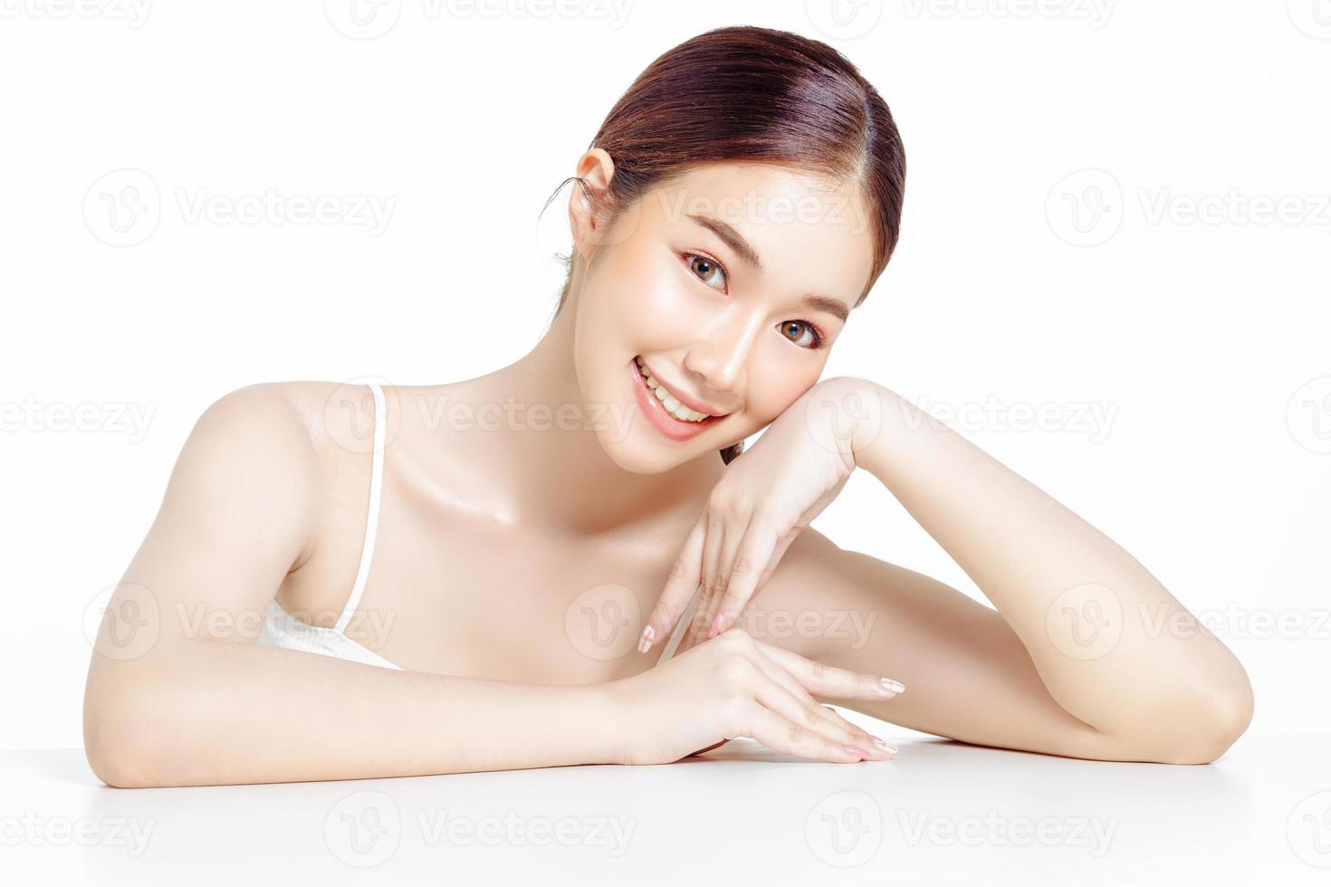 Asian woman with a beautiful face gathered in a brown ponytail and clean fresh smooth skin. photo