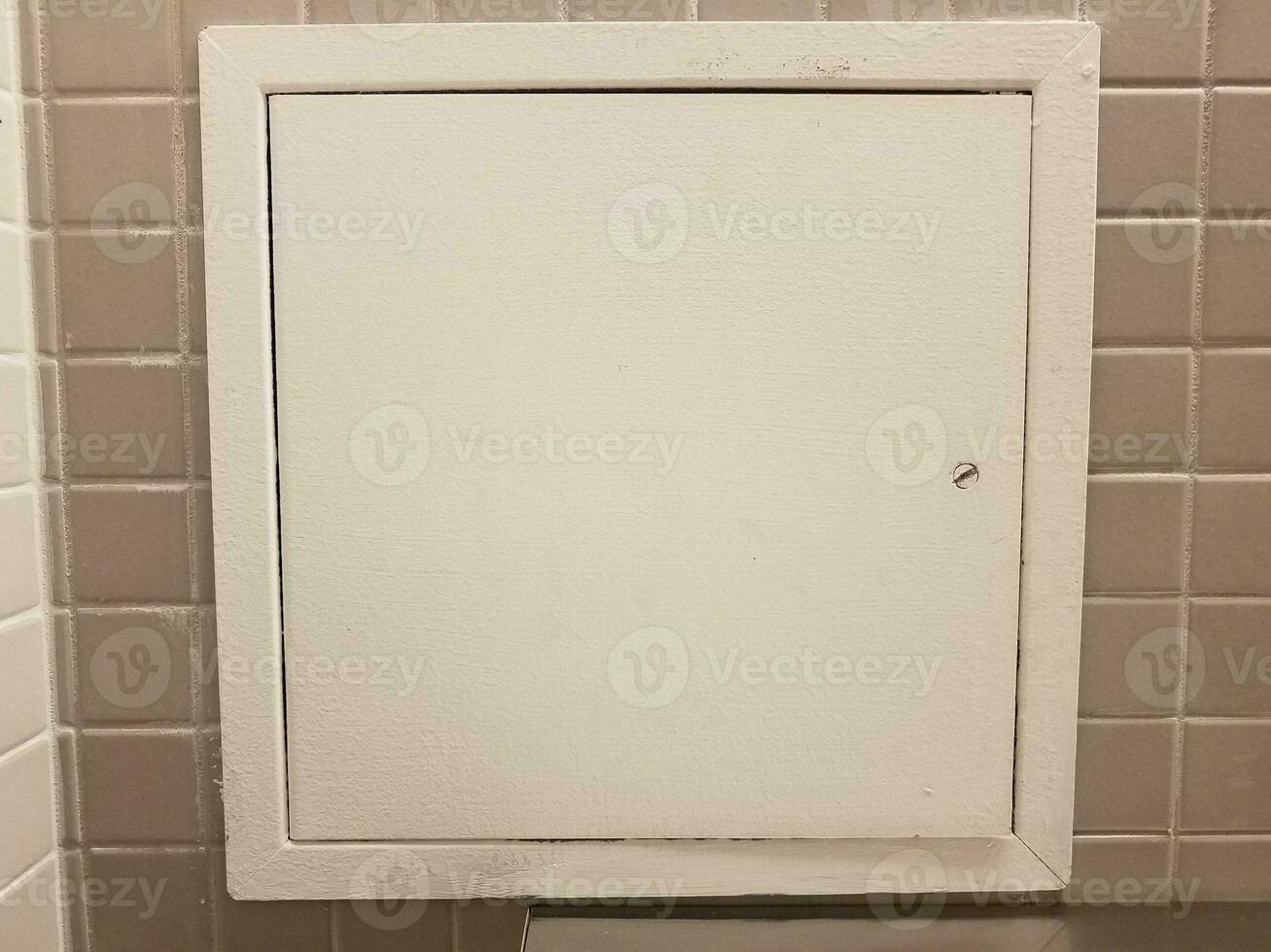 puerta o panel blanco sobre azulejos grises en el baño foto