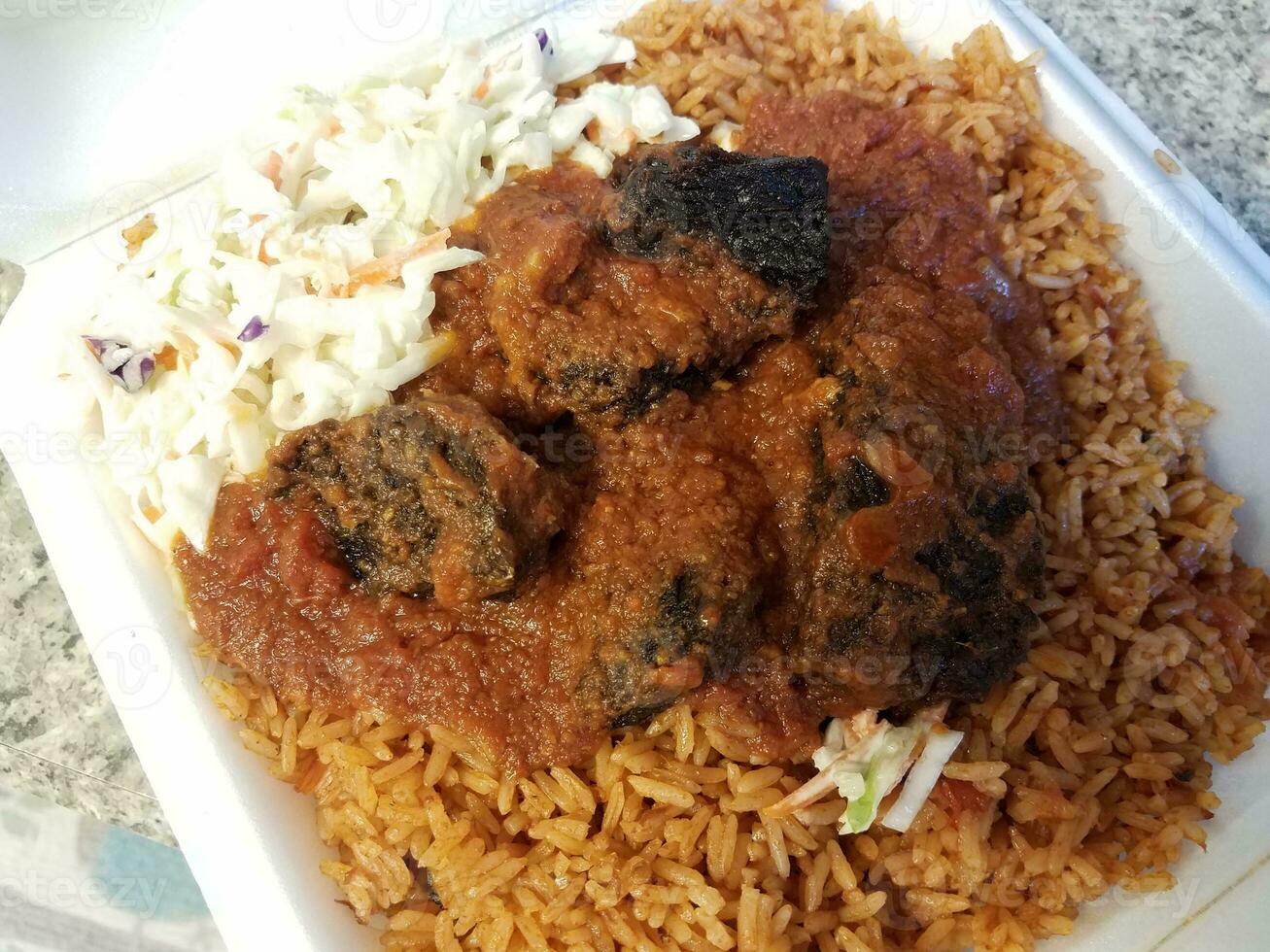 spicy goat and rice African food in container photo
