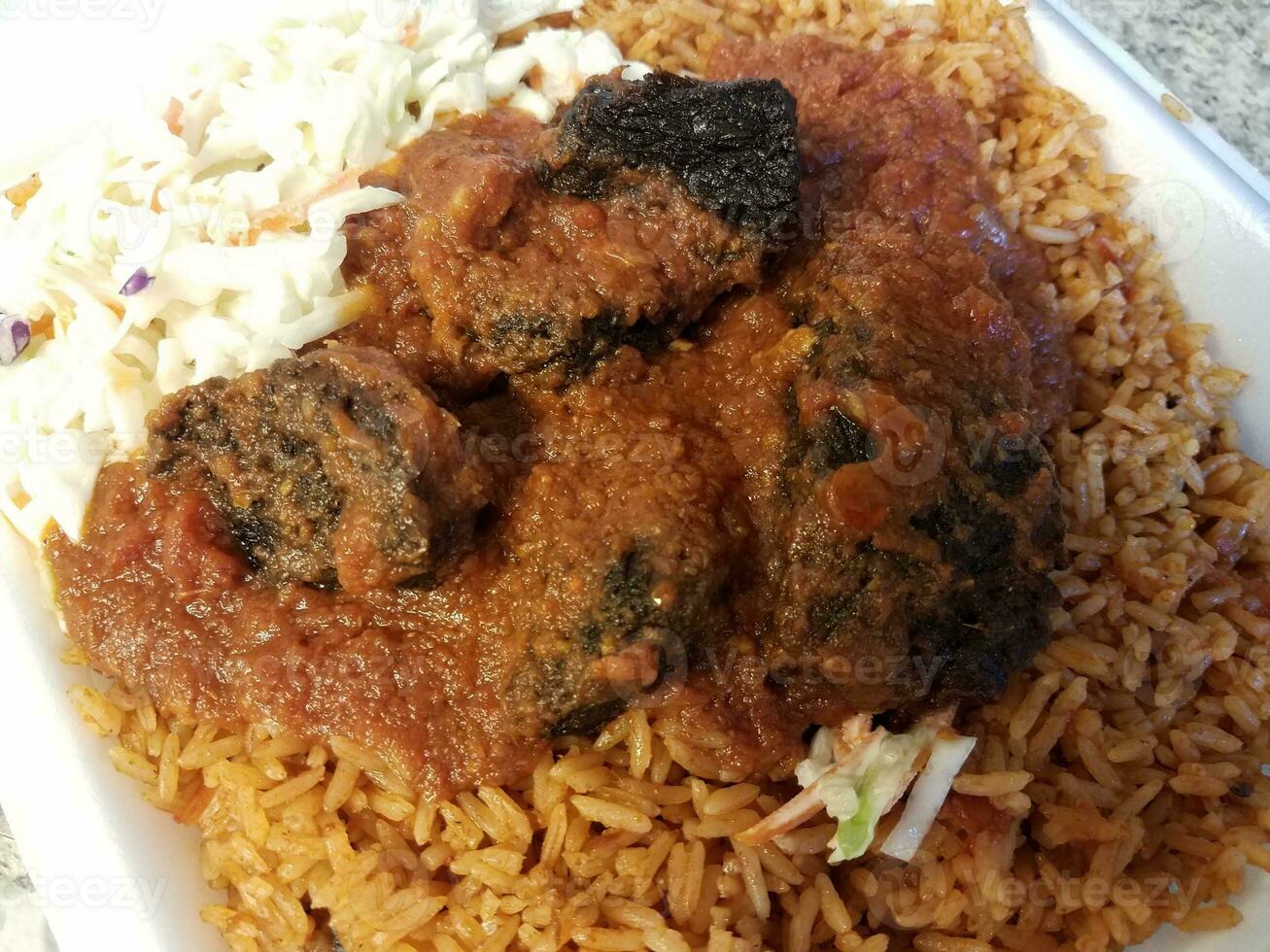 spicy goat and rice African food in container photo