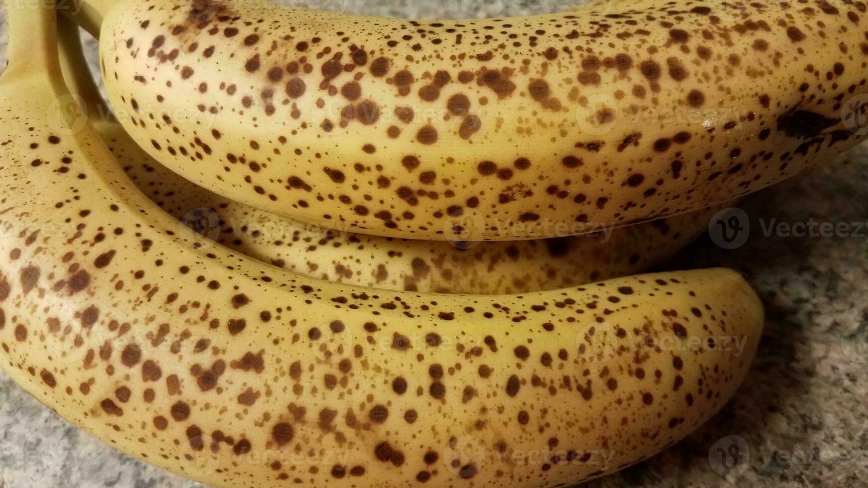 ripe banana fruit with spots on counter photo