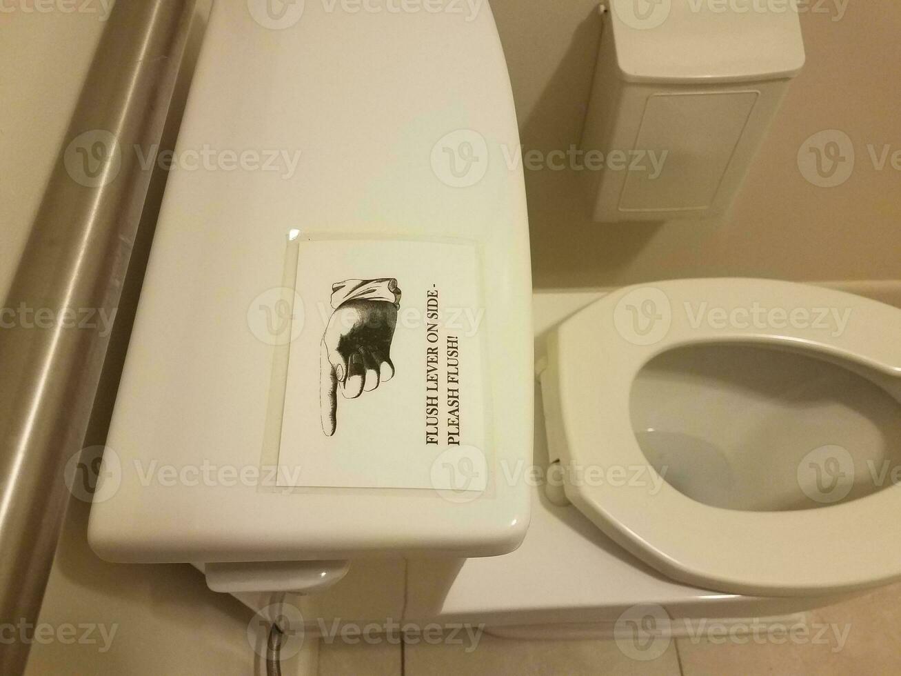 palanca de descarga en el costado del letrero del inodoro en el baño o en el baño foto