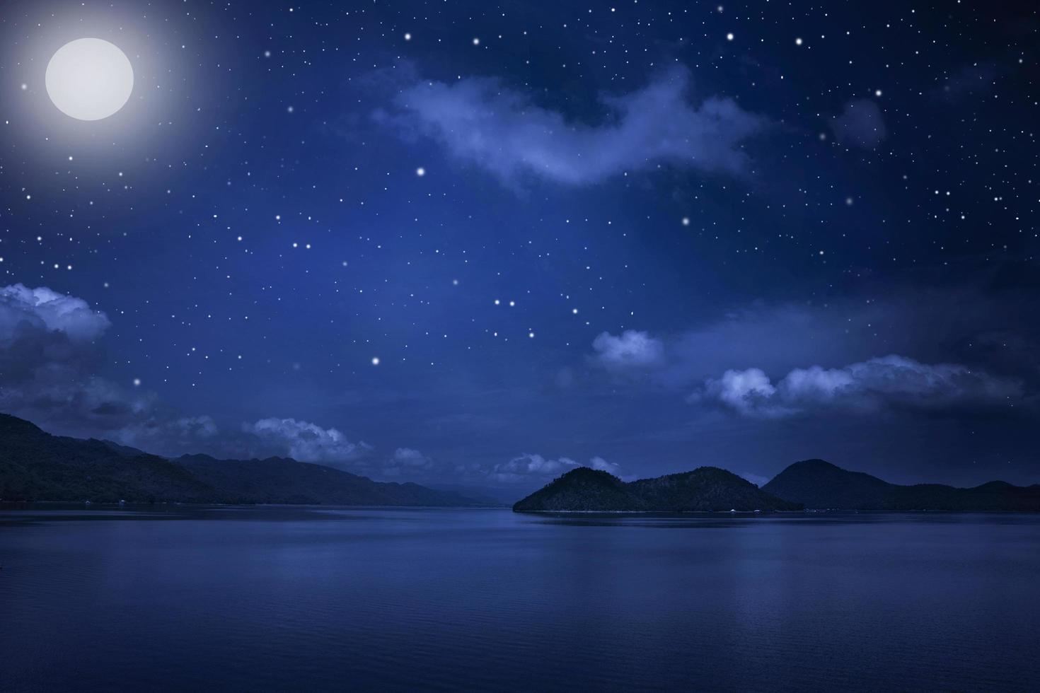 vista del paisaje montañoso y cielo nocturno estrellado con estrellas y luna en el fondo del paisaje nublado foto