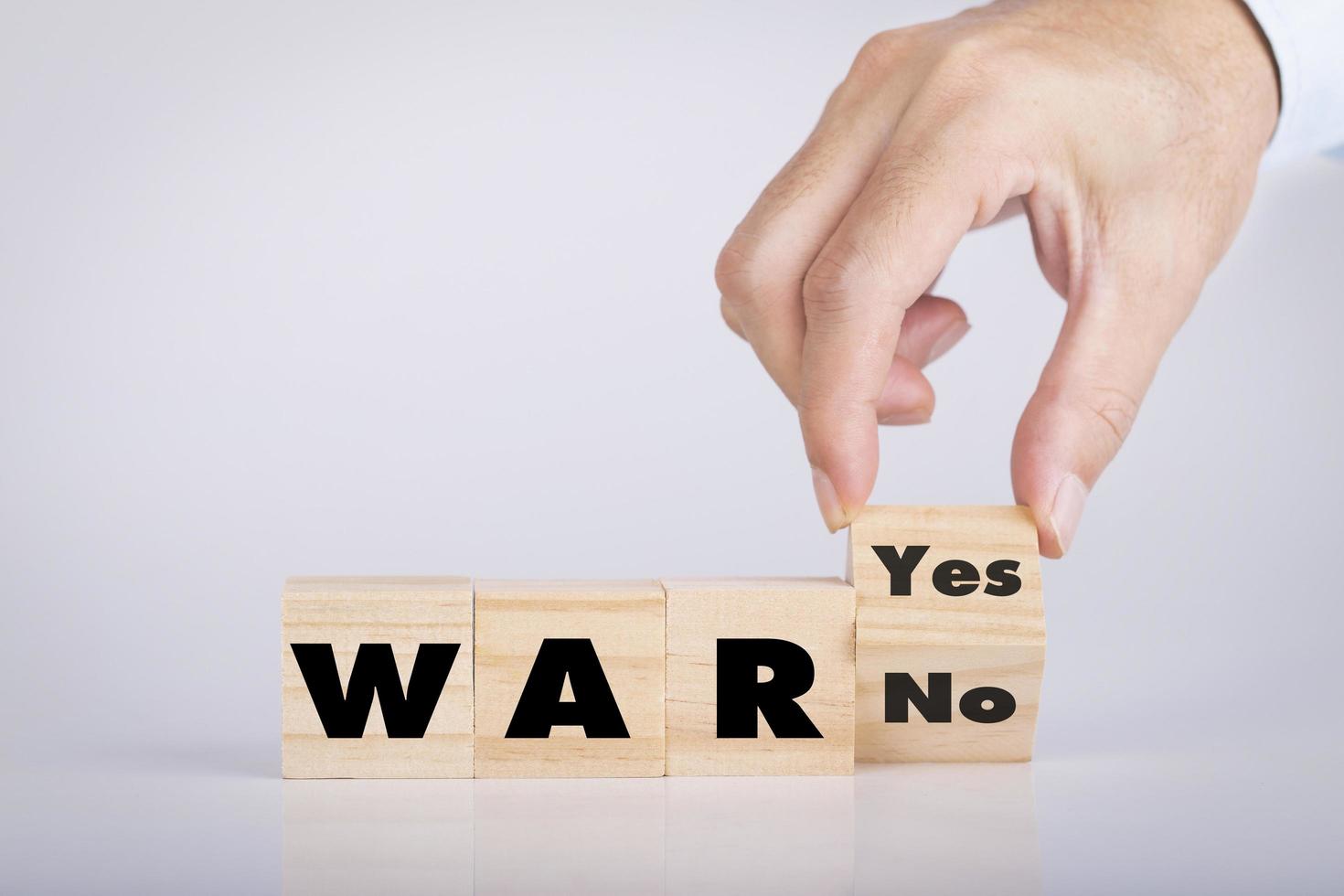 Hand holding chooses wooden block cubes with War word yes or no photo