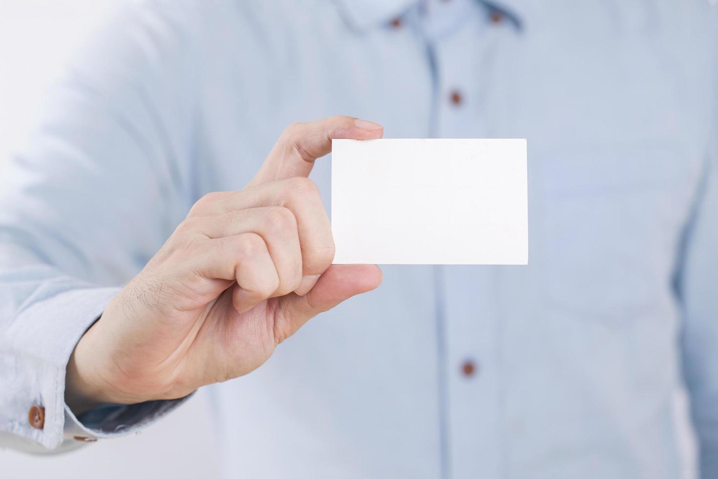 Businessman showing a blank business card on white background photo