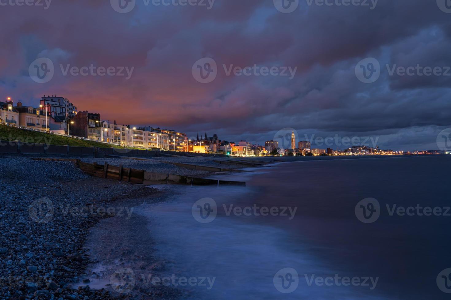 Sunset at the coastline of Le Havre in Normandy, France. Church of St. Joseph is seen the background photo