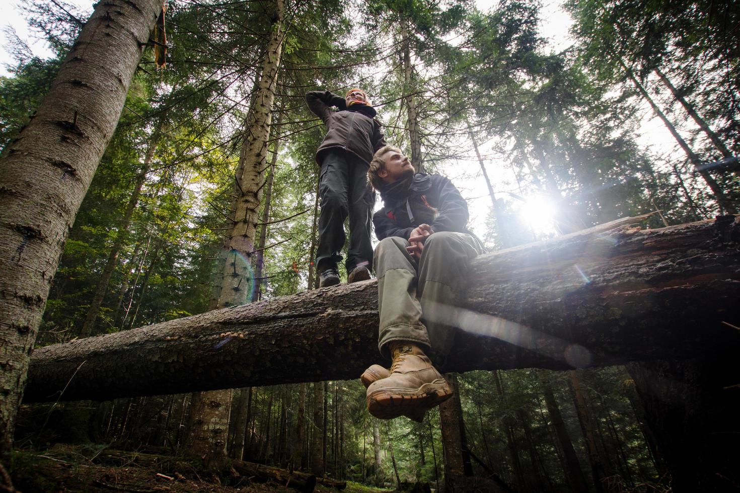 Pareja joven excursionistas con termos en el bosque, viajeros en mauntains bebiendo té o café foto