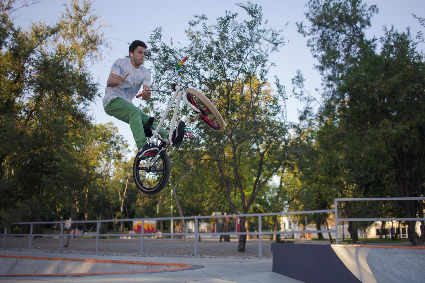 BMX rider training and do tricks in street plaza, bicyxle stunt rider in cocncrete skatepark photo