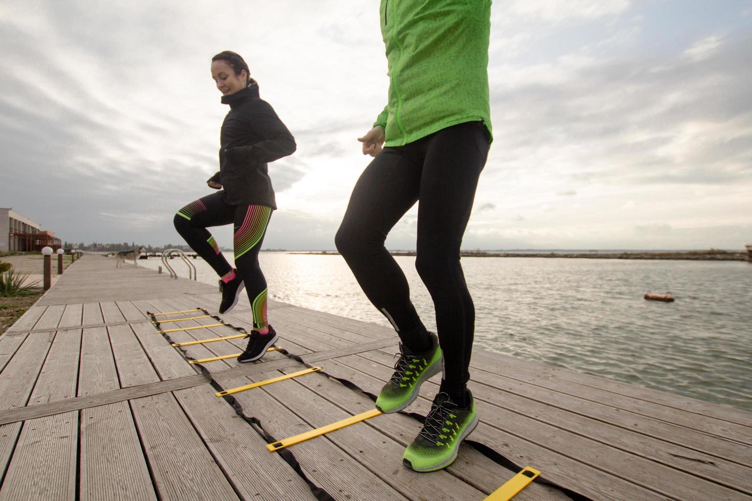 group of young people training outdoors, runners exercises, sea or river background photo