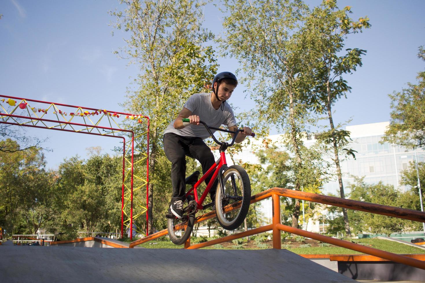 BMX rider training and do tricks in street plaza, bicyxle stunt rider in cocncrete skatepark photo