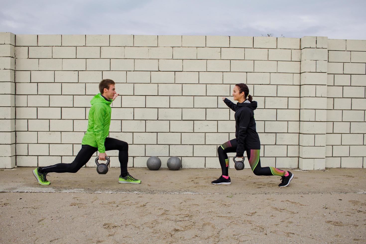 group of young people training outdoors, runners exercises, sea or river background photo