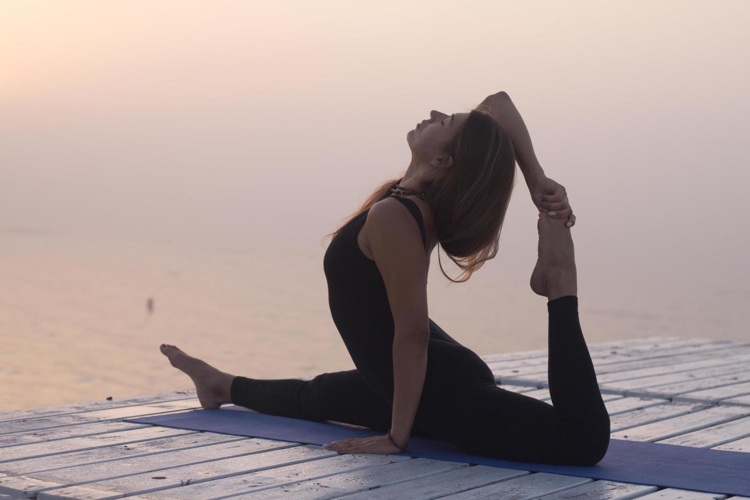 young woman posing in yoga asans, morning sea background 7713712