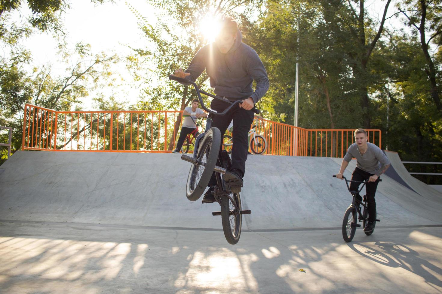 Group of young people with bmx bikes in skate plaza, stunt bicycle riders in skatepark photo